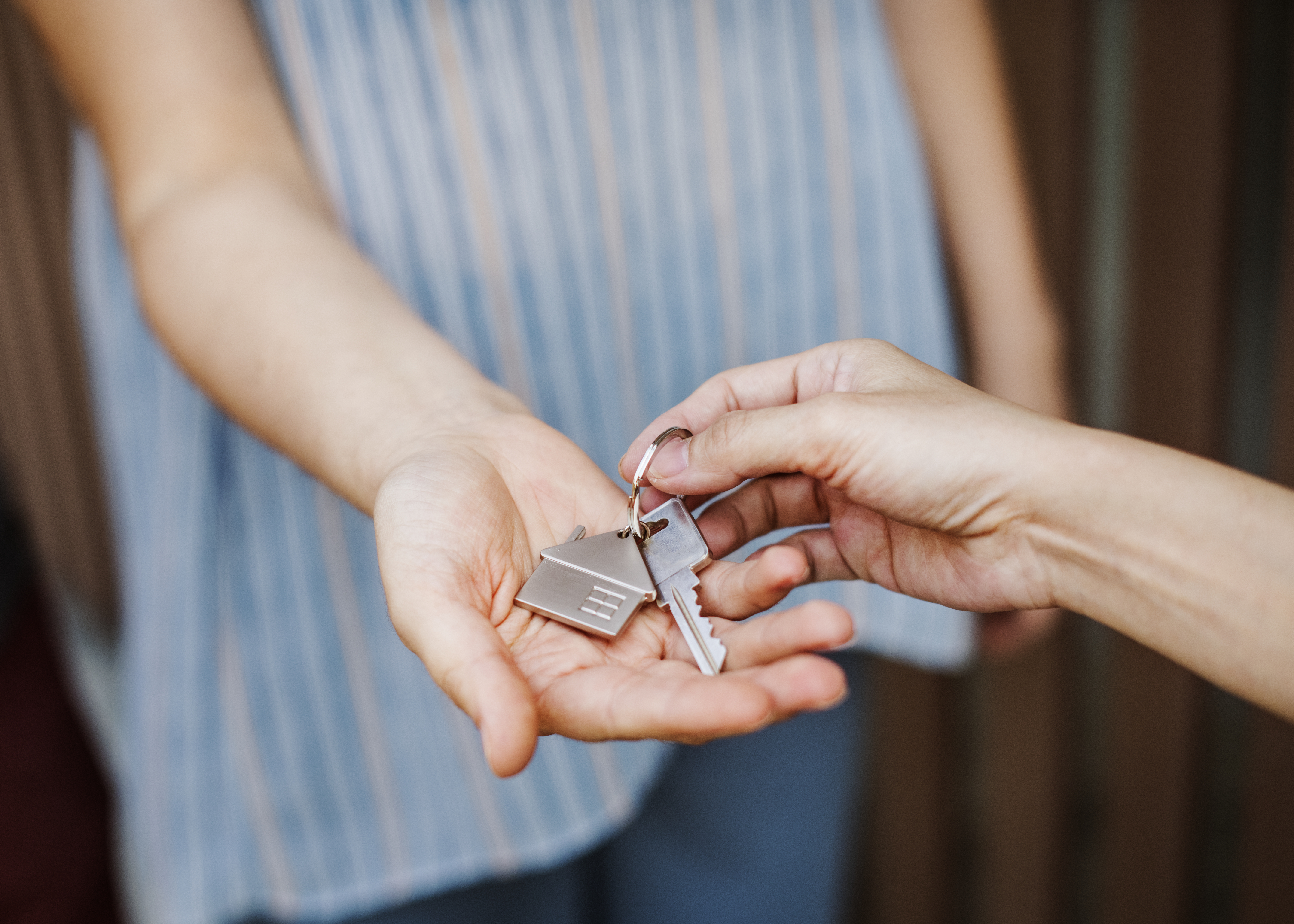 Keys to a new home being placed in someones hand. 